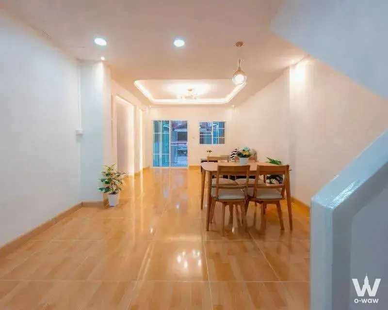 Arden house dining area with light wood table, chairs, tray ceiling, and pendant light