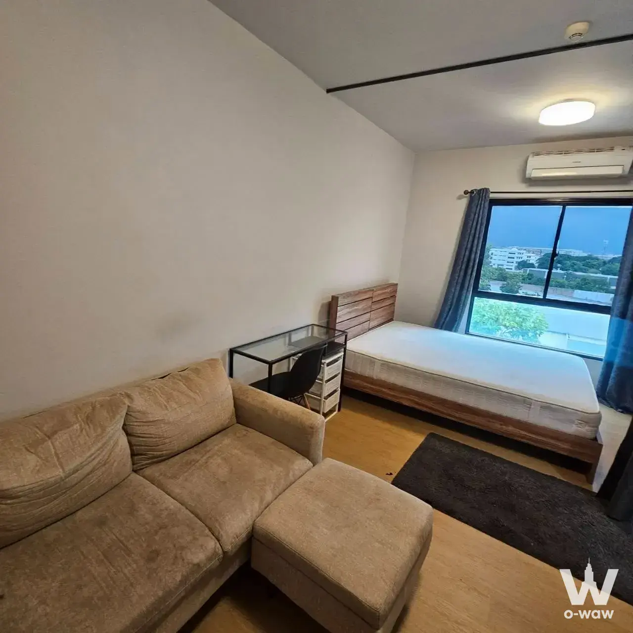 1-bed condo for sale in Unio Ramkhamhaeng-Serithai with compact bedroom layout, reclaimed wood bed frame, and large window