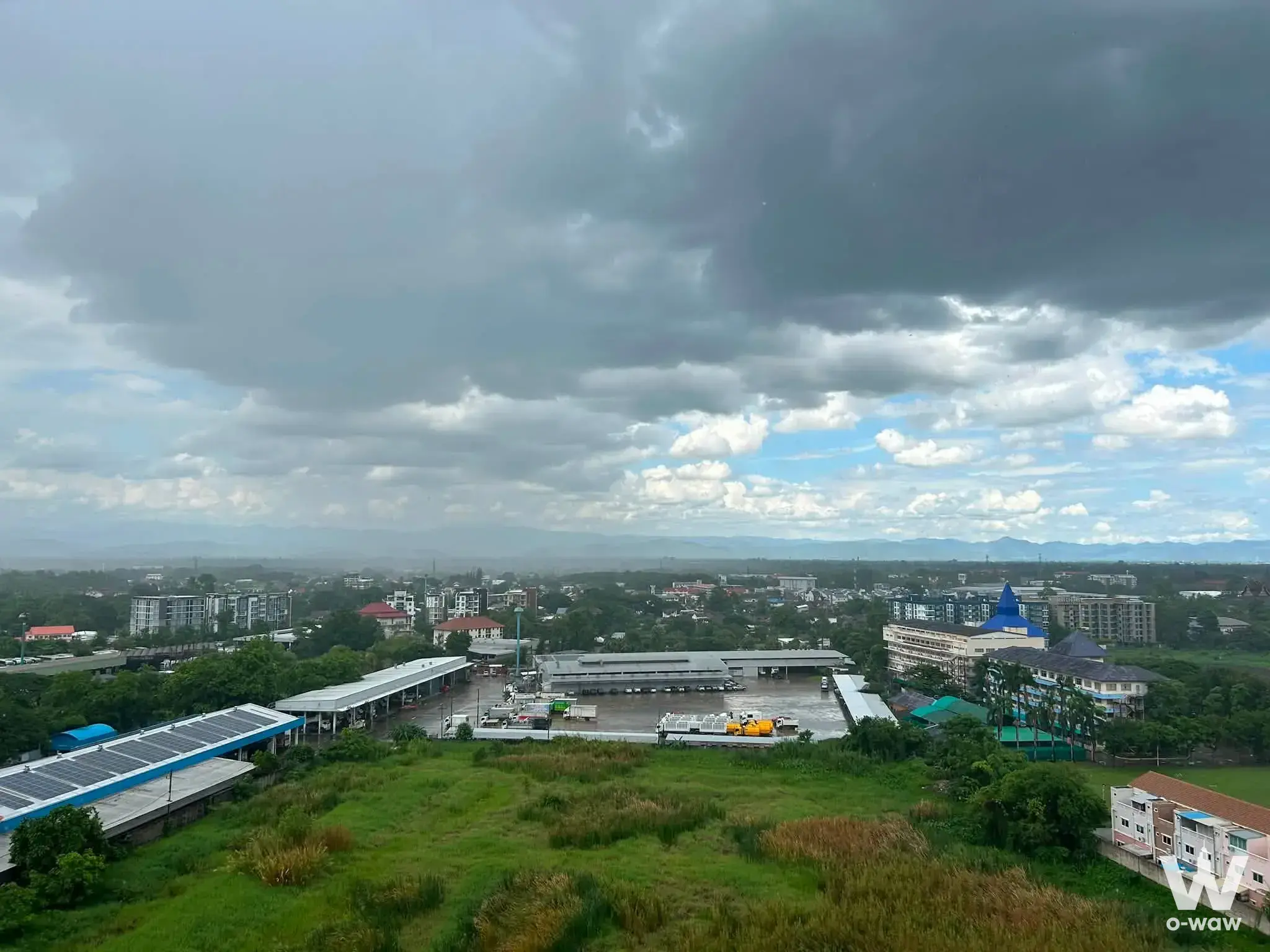 Storm clouds over Chiangmai cityscape with distant mountains and green canopy near Supalai Monte II