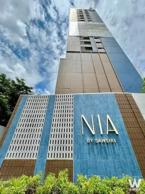 NIA by Sansiri condo exterior with blue ceramic tile facade and white concrete lattice screens