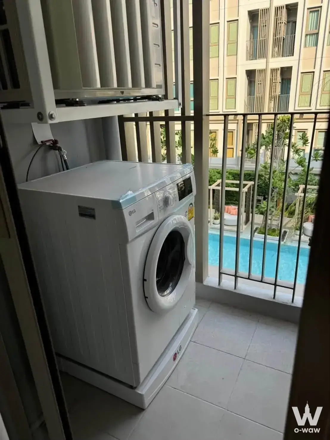 Utility balcony with LG washing machine and pool view at Aspire Pinklao - Arunmararin 1-bed condo for rent