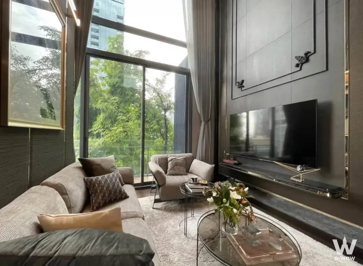 Living room in LAVIQ Sukhumvit 57 condo with grey sofa and floor-to-ceiling glass doors