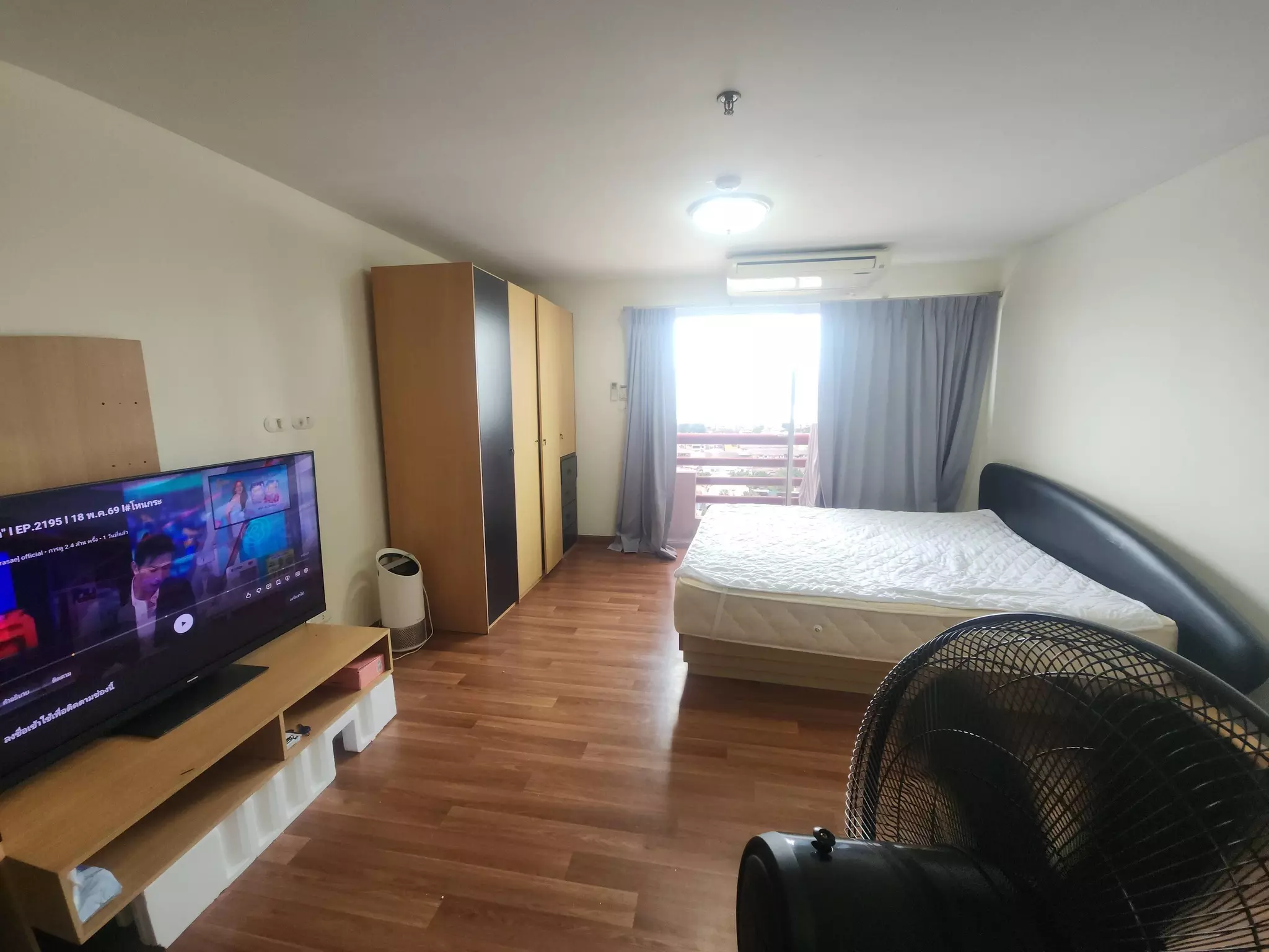 Studio bedroom with wood flooring and TV in Master View Executive Place condo