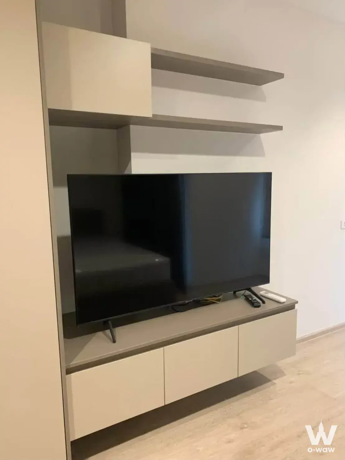 Minimalist living room media wall in Ideo Sathon-Wongwian Yai with floating cabinetry and TV