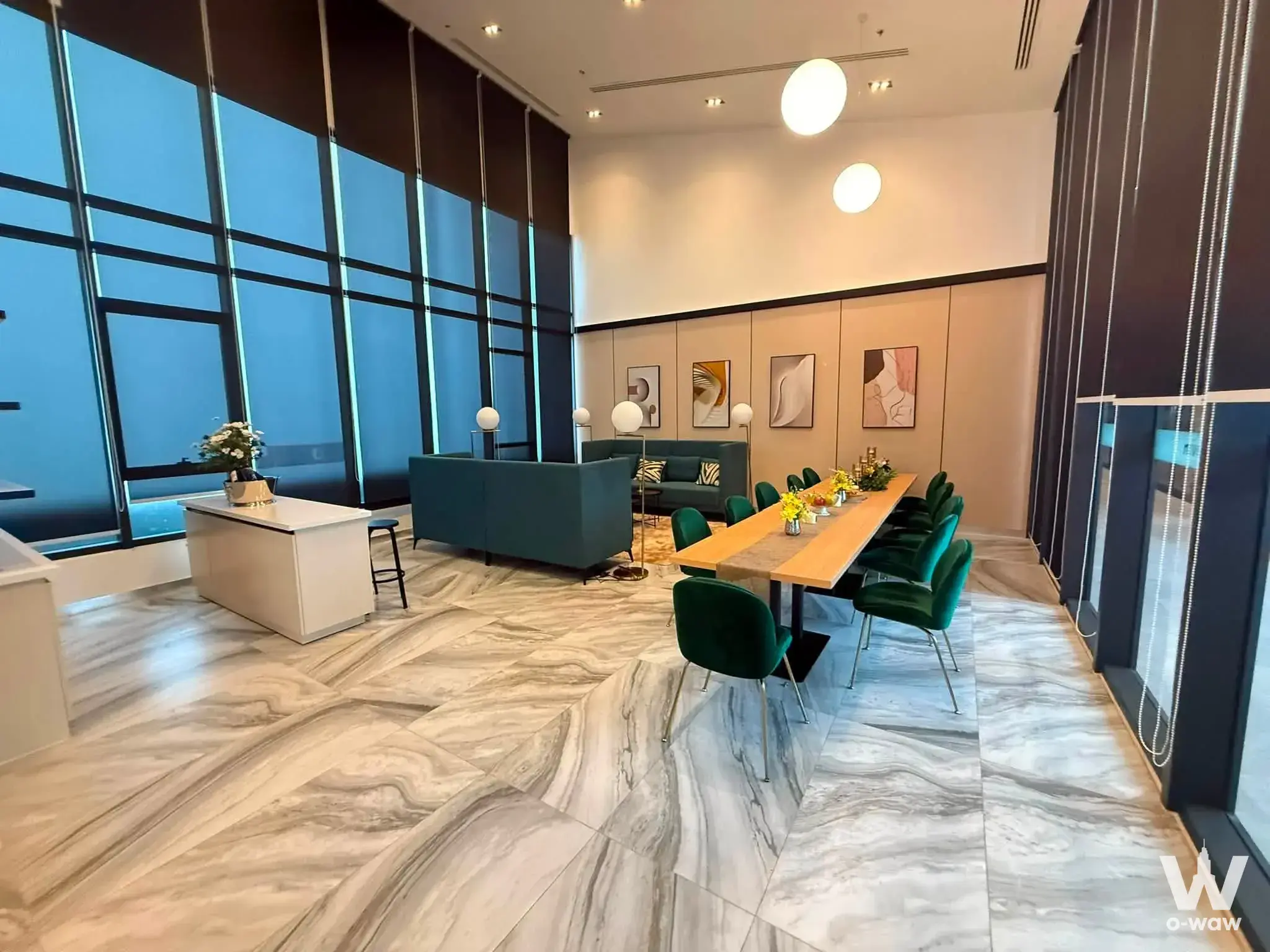 Luxury double-height lounge in The Livin Ramkhamhaeng with emerald chairs and marble flooring