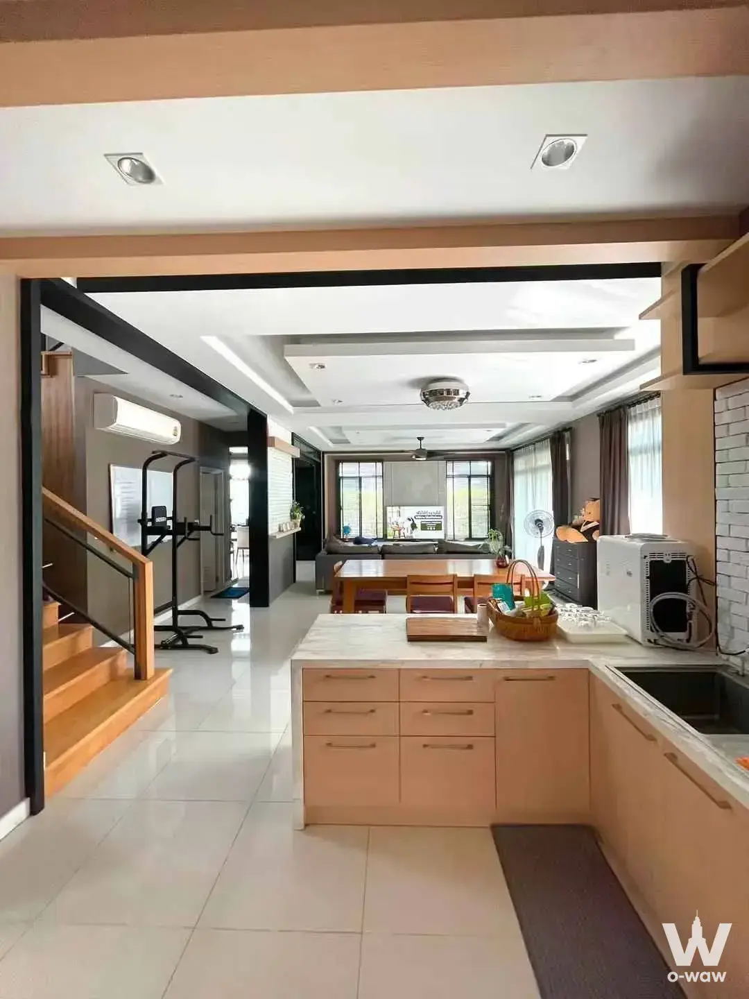 3-bed house for rent in The Palm Pattanakarn with open-plan kitchen featuring white marble countertops and a wooden dining