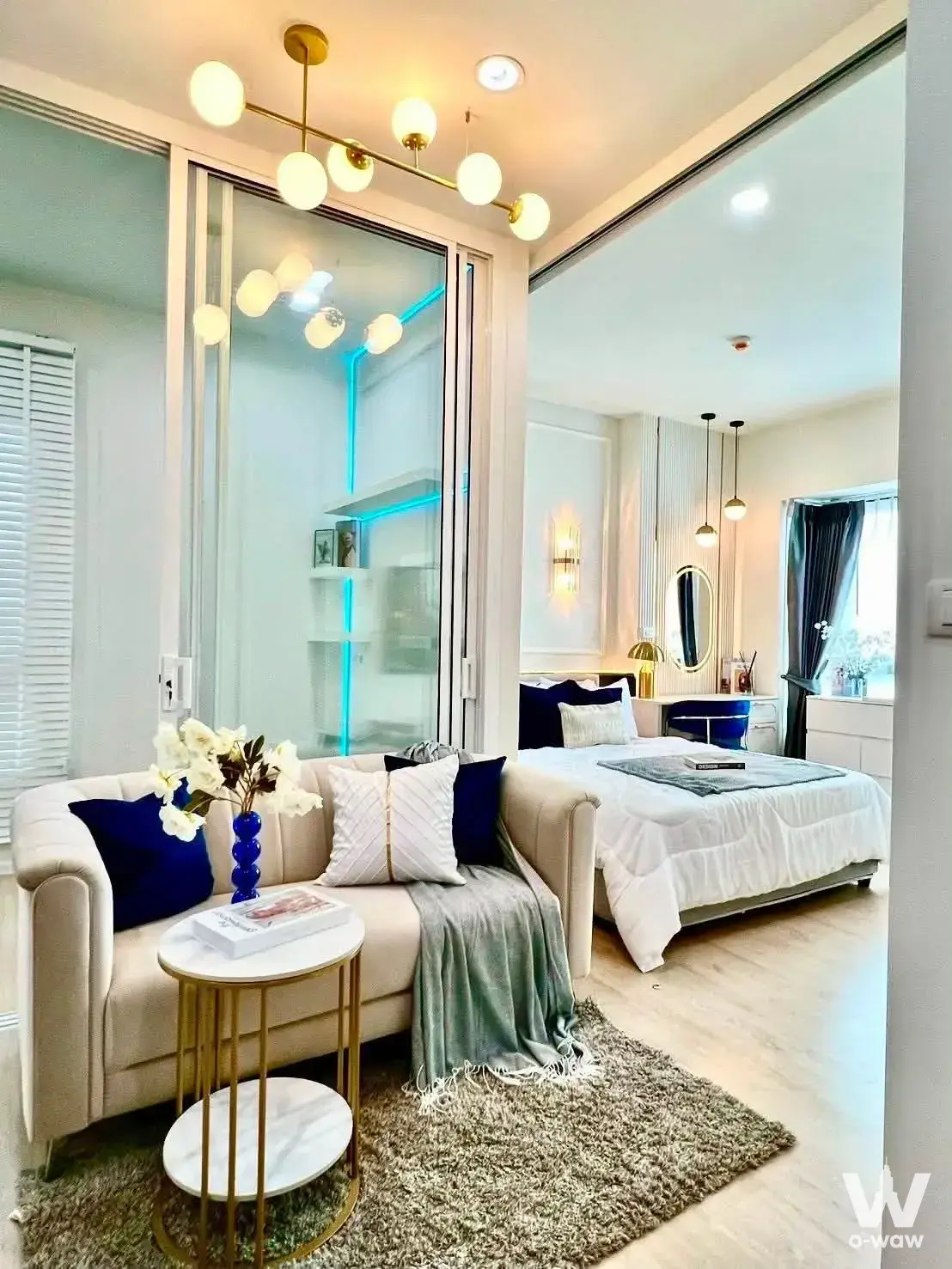 Cream and navy 1-bed condo for rent in S1 Rama 9 featuring gold accents, orchids, and LED lighting