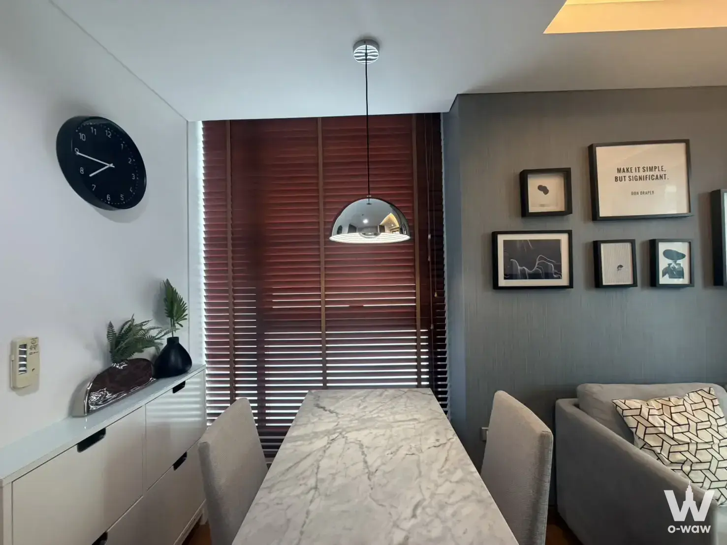 Dining area in The Lumpini 24 with a marble table and gallery wall art
