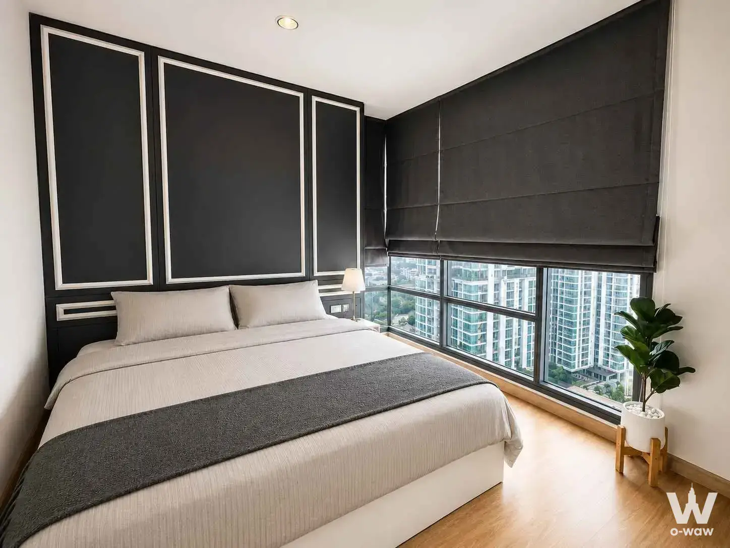 Bedroom in Rhythm Sukhumvit 42 with queen bed and corner windows overlooking the city