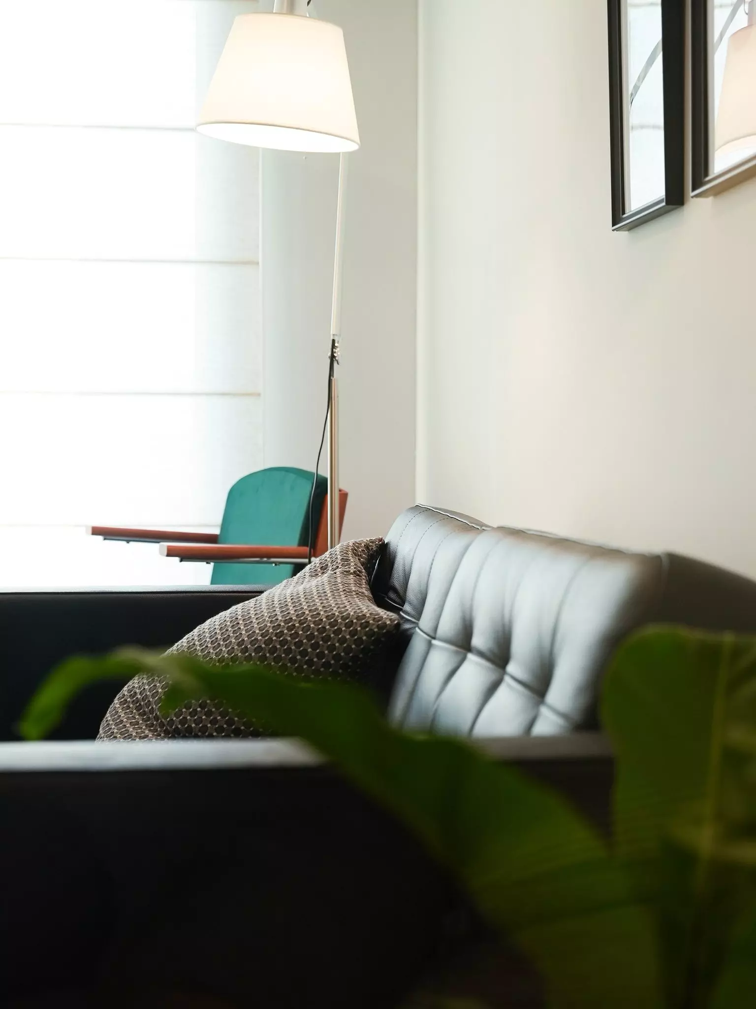 Regent Home Bangna one-bedroom condo living corner with teal armchair, black sofa, and natural light