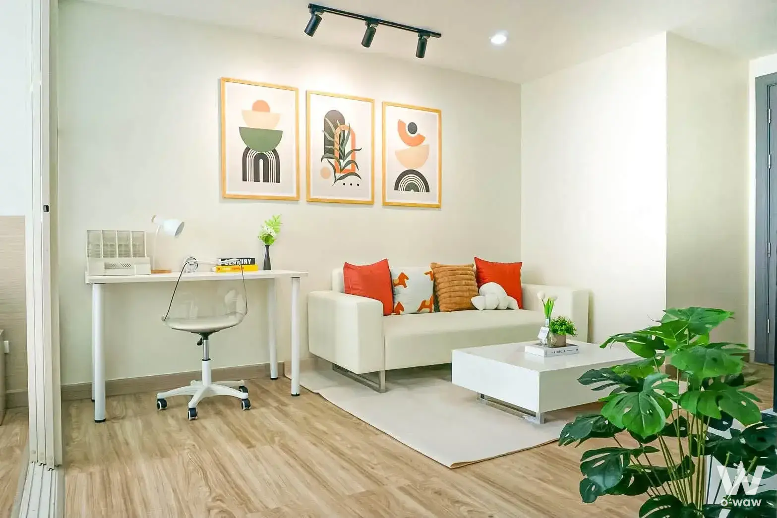 Bright living room in Elements Srinagarindra condo with cream sofa, horse print pillow, and minimalist decor