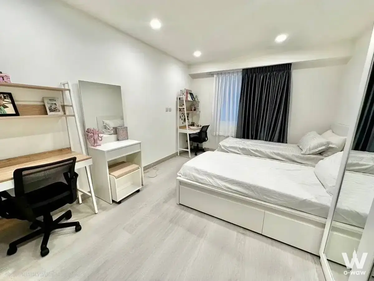 3-bed condo for sale in Royal Castle Sukhumvit featuring two beds, white desks, and light-wood accents