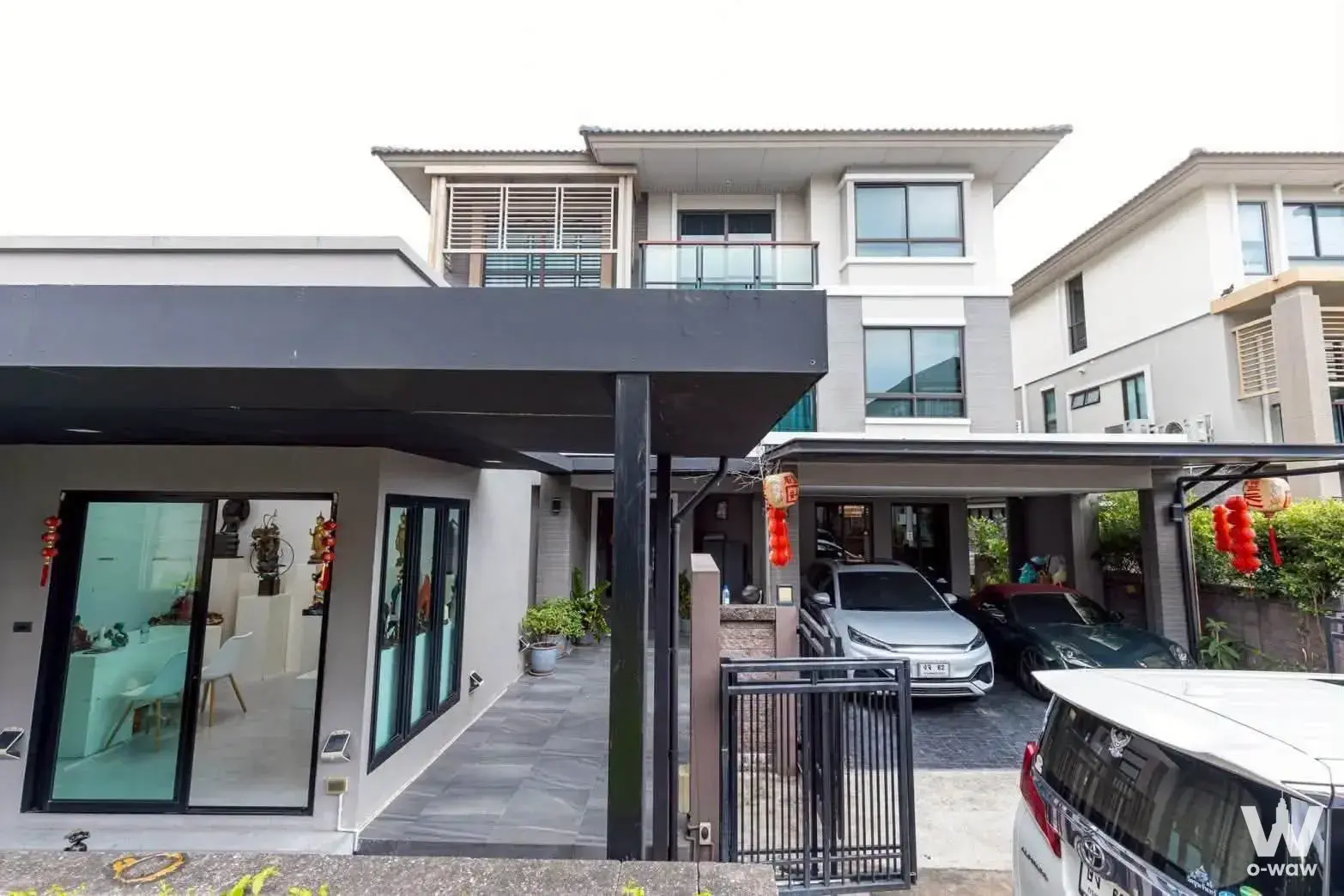 4-bed house for rent in Passorn Songprapa showing modern grey exterior, carport with SUV, and glass doors