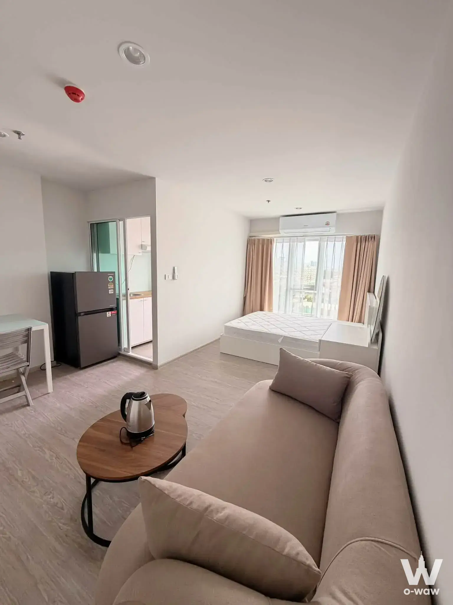 Studio condo for rent in Regent Home Bangna featuring a queen bed, city view balcony, and modern open-plan layout