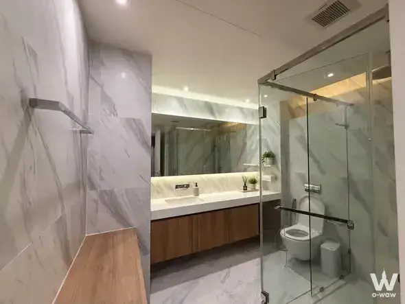 Modern bathroom with grey veining marble tiles and wood-grain vanity in MUNIQ Sukhumvit 23