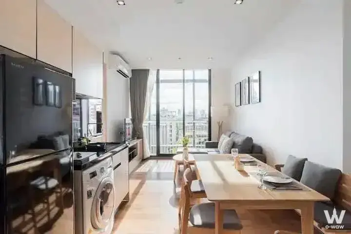 Bright open-plan living and dining area in a Park Origin Phrom Phong 2-bed condo with light wood floors