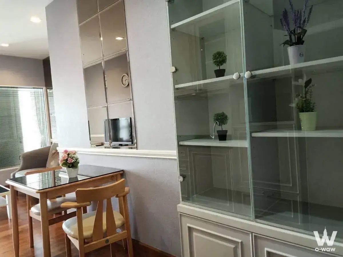 Dining area with light-wood table and built-in white cabinet in Ivy Sathon 10 condo