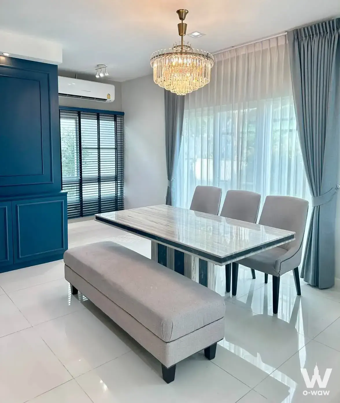 Modern dining room in a 4-bed Mantana Westgate house with marble table and teal cabinetry