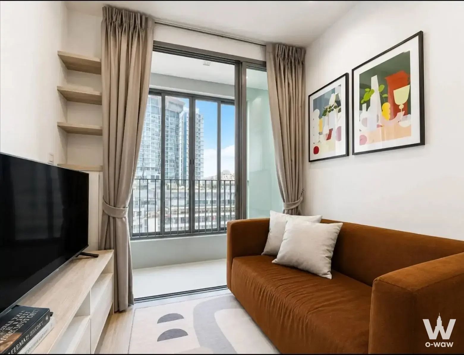 Living room with an orange sofa and city view balcony in this 1-bed unit for rent in Ideo Mobi Sukhumvit 81