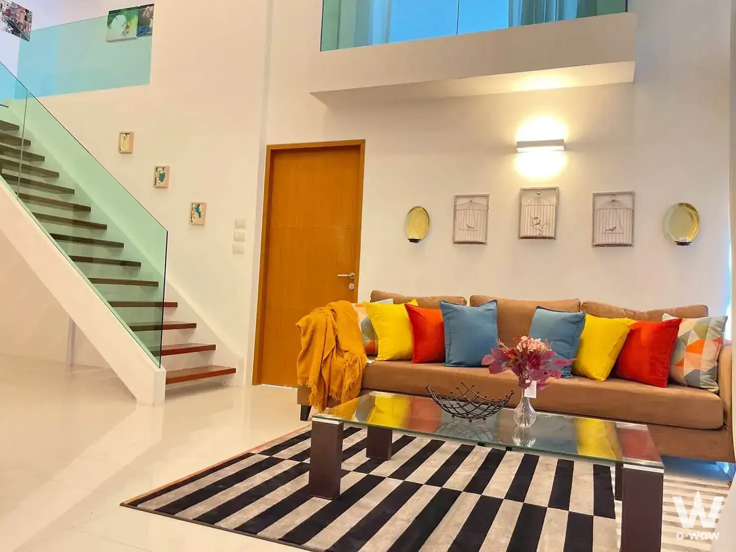 Loft living room in The Sanctuary Wong Amat with double-height ceilings and floating staircase