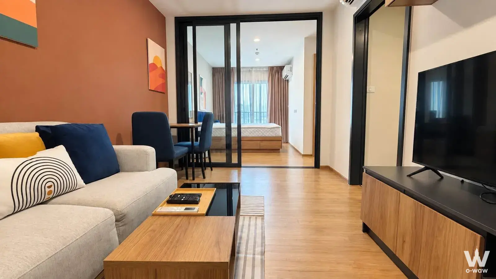 1-bed condo for rent in The Line Vibe showcases an open-plan layout with terracotta accent wall and navy accents