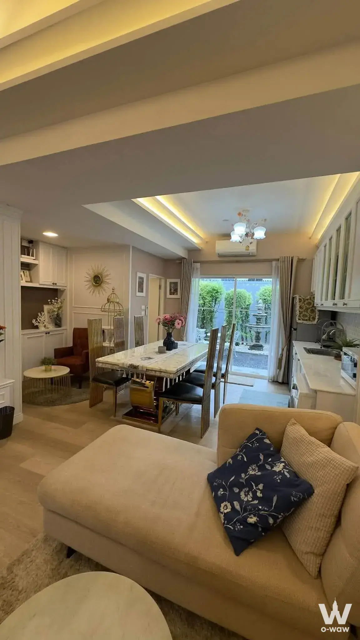 Open-plan living and dining area in a 2-bed townhouse for rent in Indy1 Bangna has a marble table and garden patio