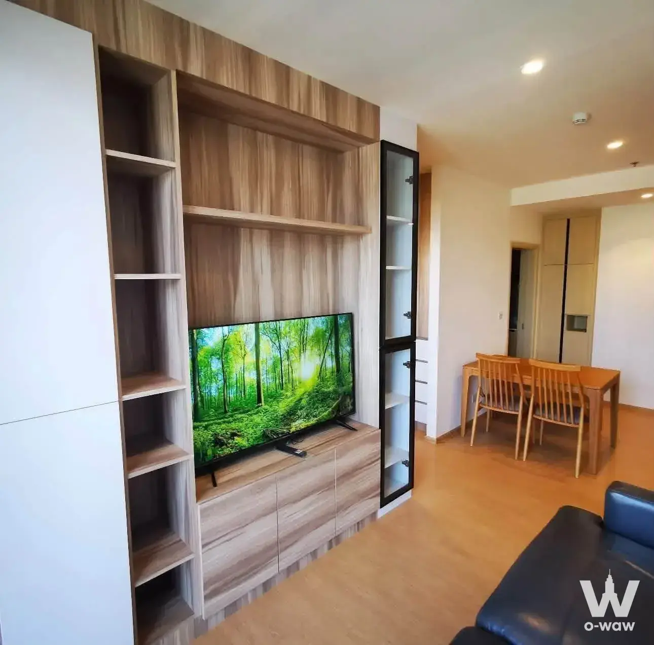 MARU Ekkamai living room with built-in wood unit, TV, and dark blue sofa