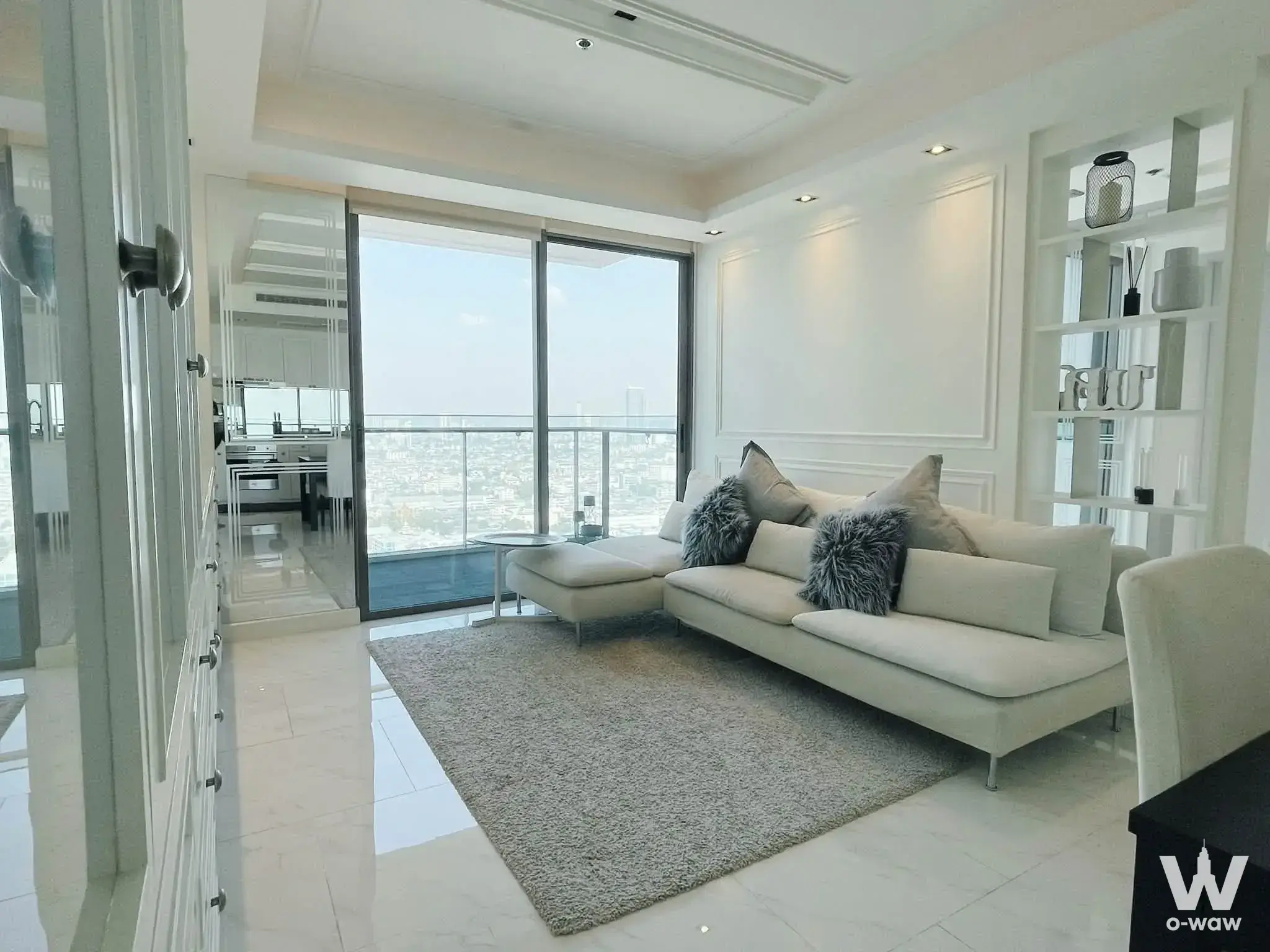 Luxury 2-bed condo living room featuring cream L-shaped sofa and city skyline view at StarView Rama 3