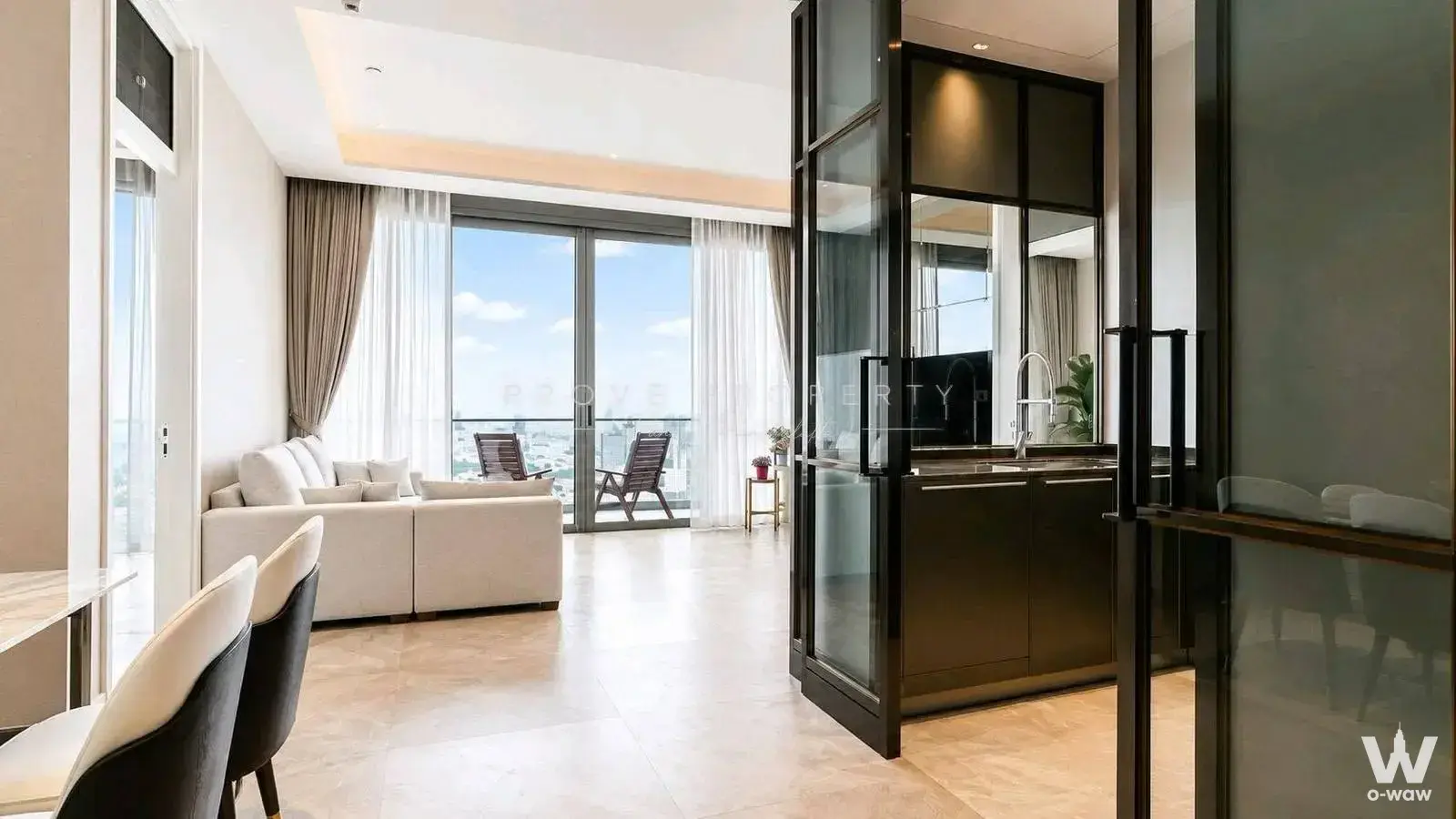 Modern luxury living room with sectional sofa, floor-to-ceiling balcony doors, and city skyline views at The Residences