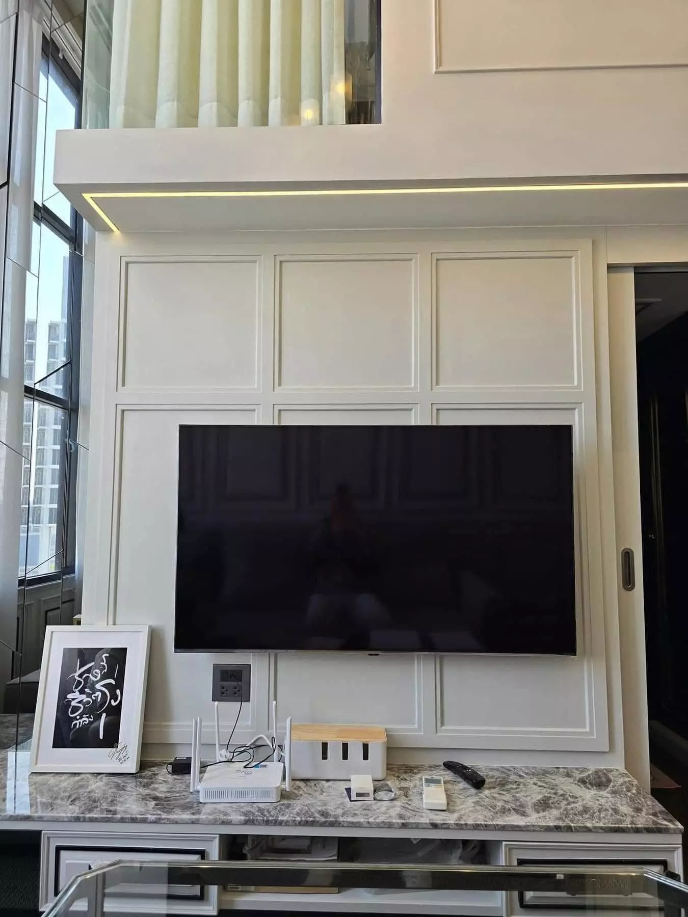 Double-height living room in KnightsBridge Prime Sathon with marble console and city view