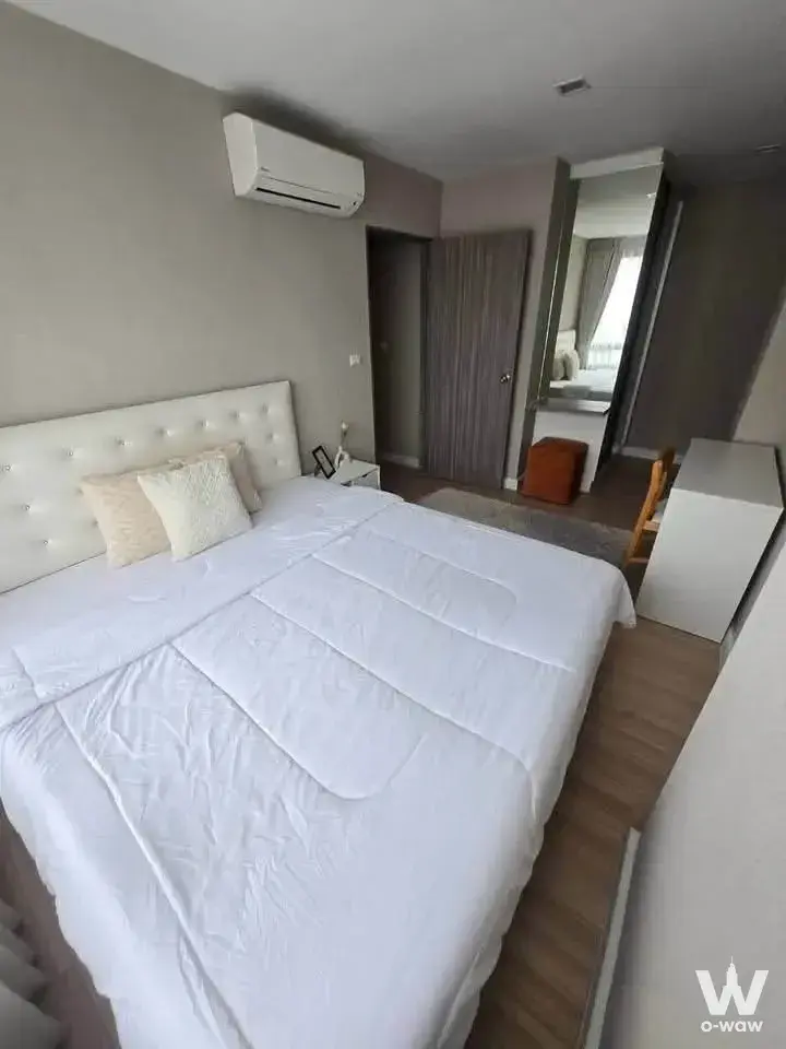Furnished bedroom in a 2-bed Metro Luxe Ratchada condo with a white queen bed, dark wardrobe and full-length mirror