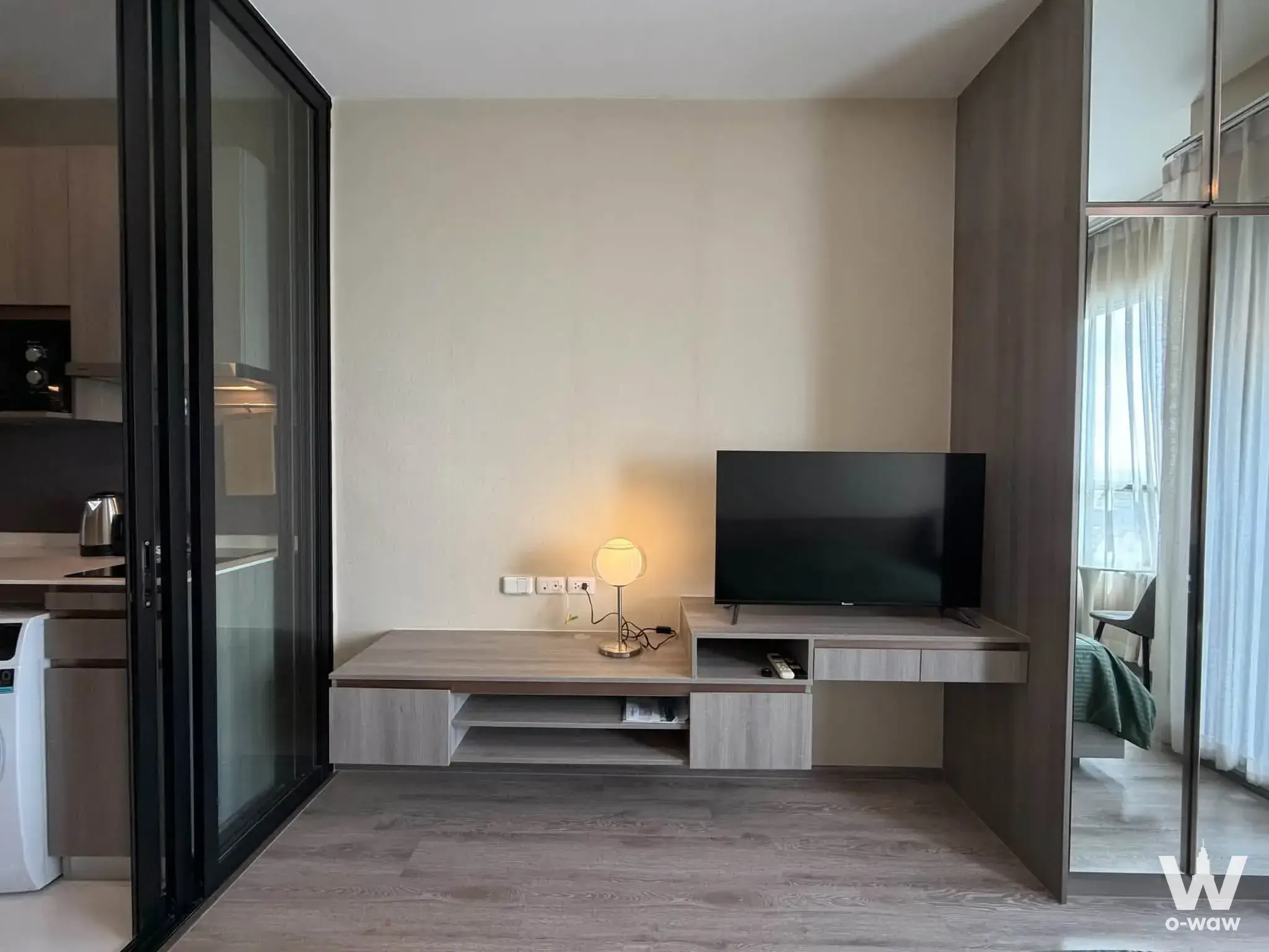 1-bed condo for sale in KnightsBridge Prime Onnut with grey laminate floors and a floating media console