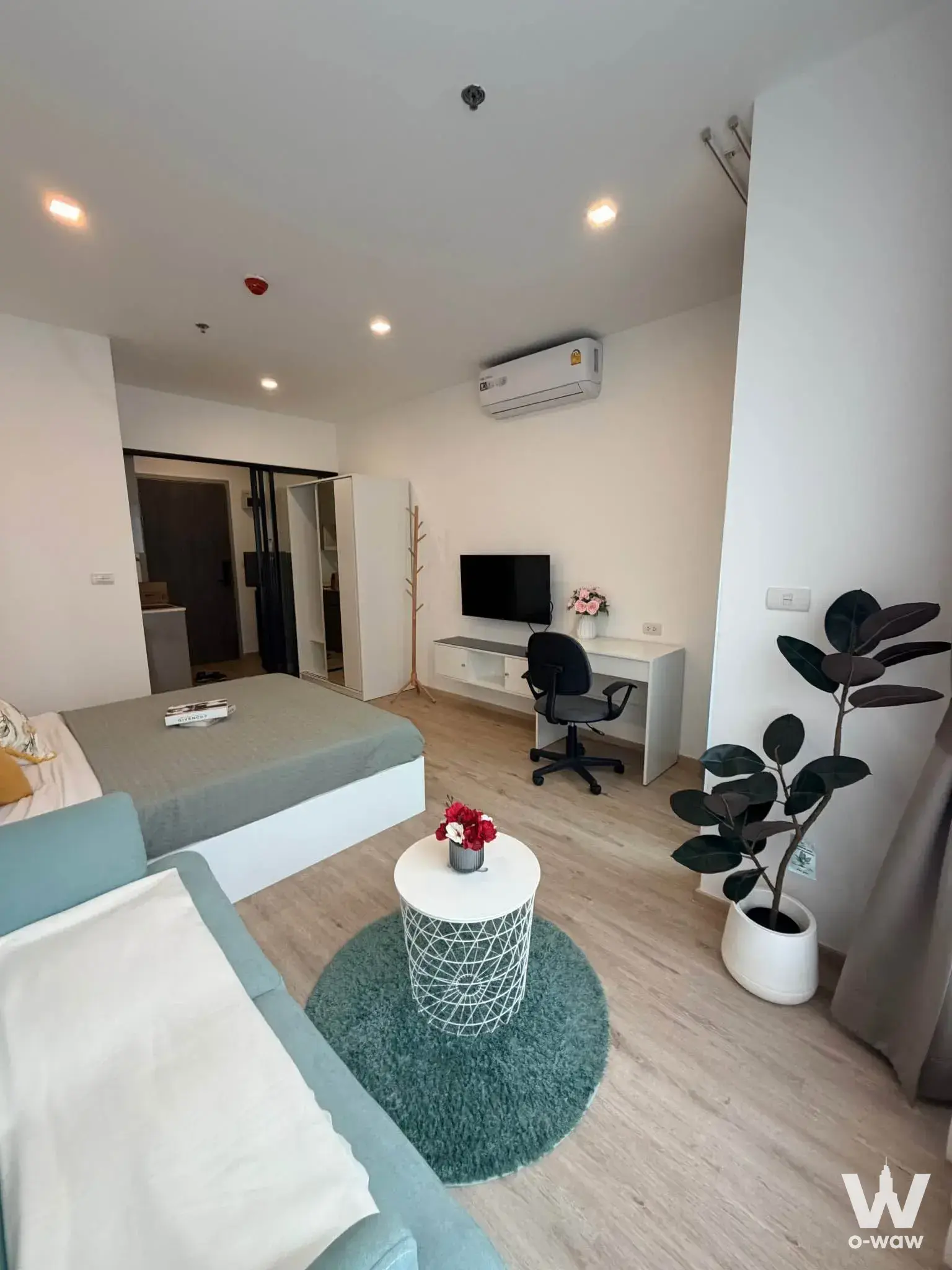 Furnished studio bedroom in The Rich Rama 9 Srinakarin with light blue sofa and mirrored wardrobe