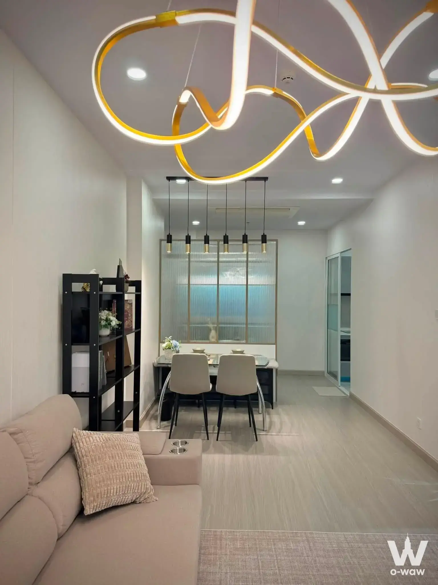 Open-plan living area in a Premier Condominium 2-bed rental with beige sofa and gold sculptural ceiling light