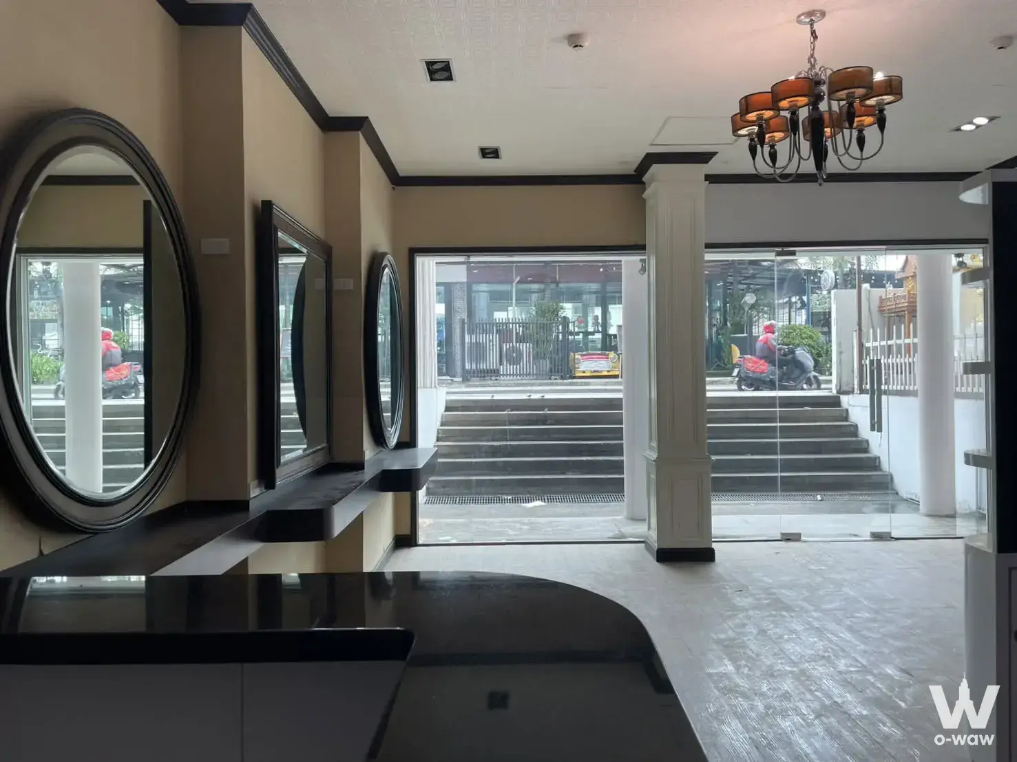 Modern lobby with black reception desk and mirrors at Le Rich Condominium for rent