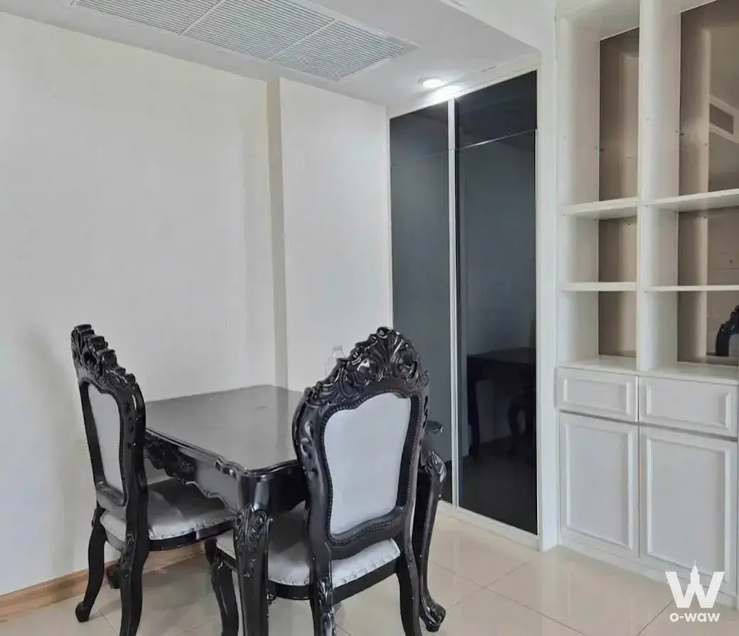 Supalai Wellington II dining area with black lacquered table, baroque chairs, and built-in cabinetry