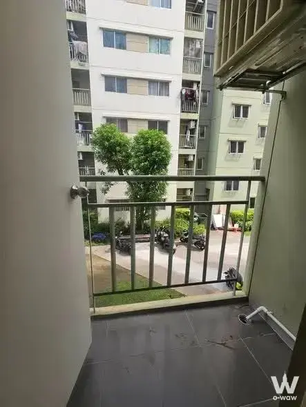 Small balcony in Lumpini Township Rangsit Khlong 1 overlooking courtyard greenery and neighboring buildings