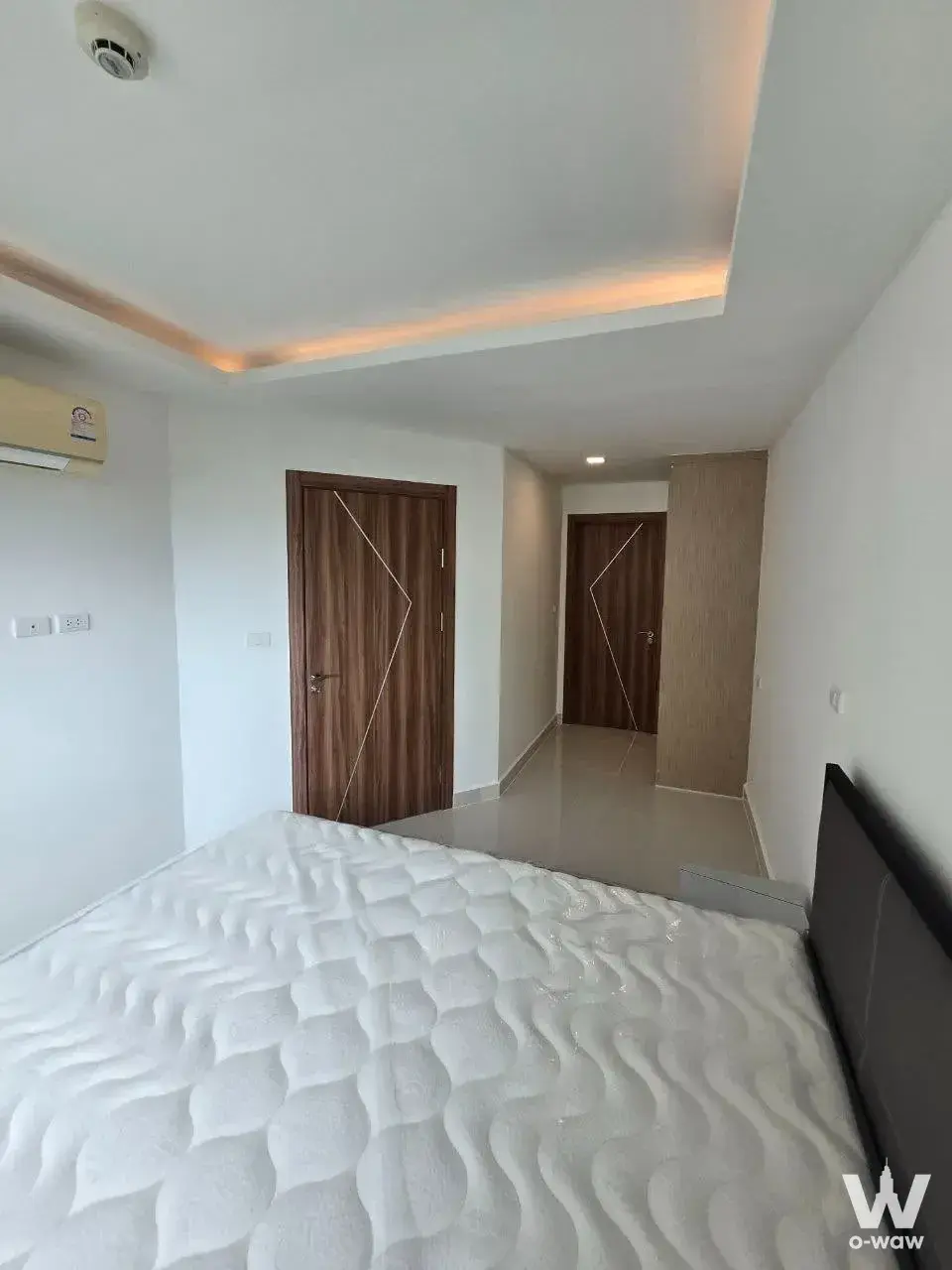 Modern bedroom with dark grey headboard and warm LED cove lighting in a Laguna Beach Resort 3 Maldives condo