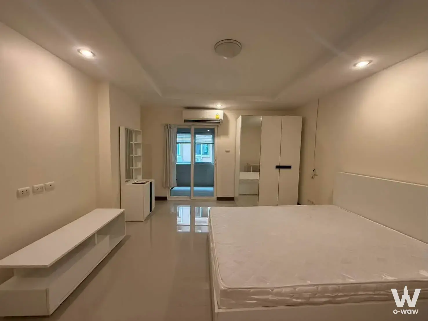 Master bedroom in a 1-bed condo for sale at Happy Condo Rachada 18 featuring a platform bed and access to a private balcony