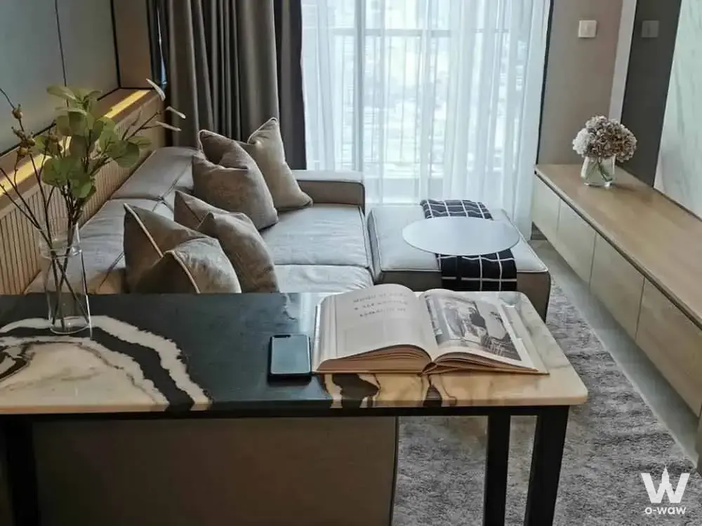Modern living room in Life One Wireless with grey sectional sofa, marble table, and city views