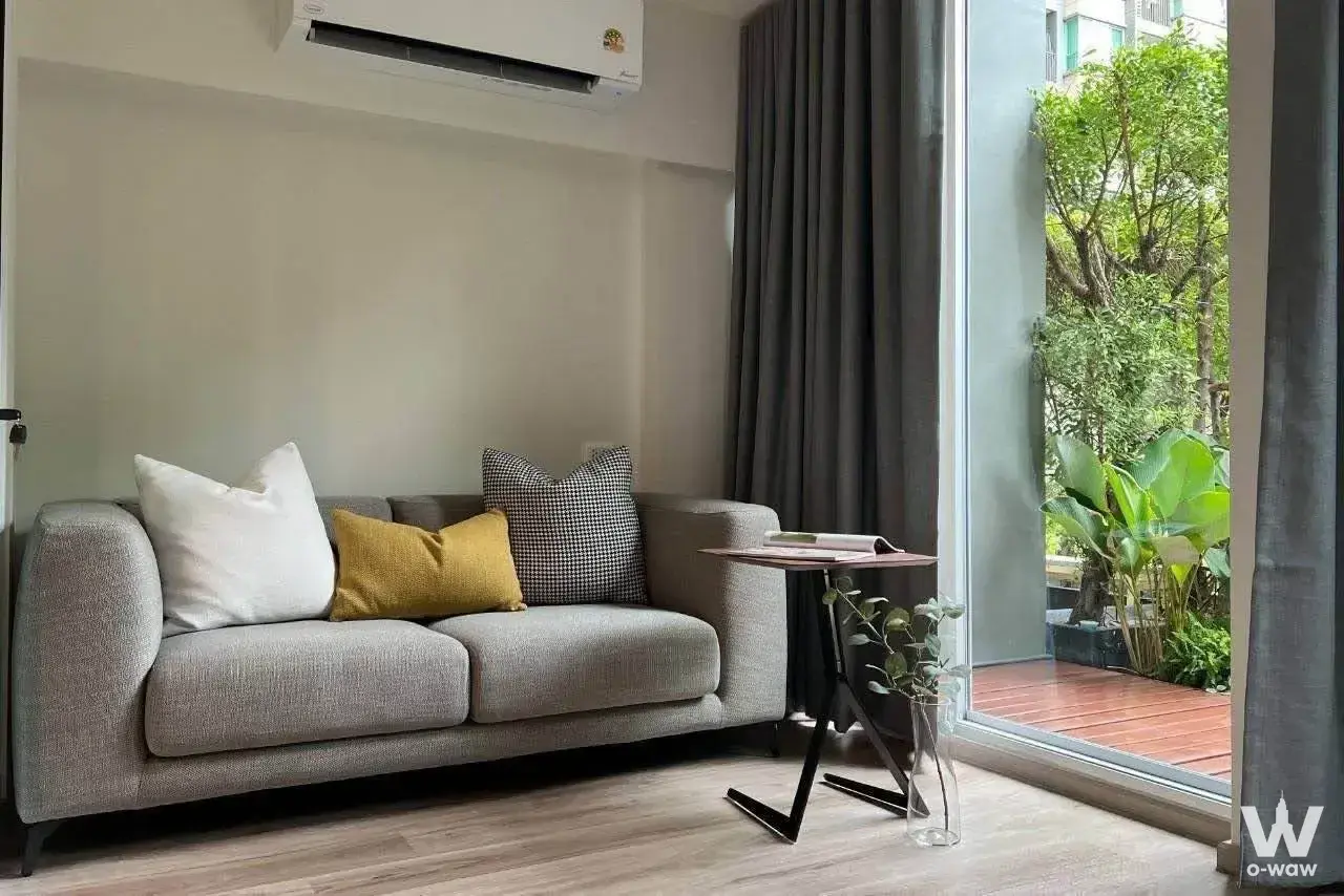 U Delight 3 rental living room has a grey sofa and a green terrace view