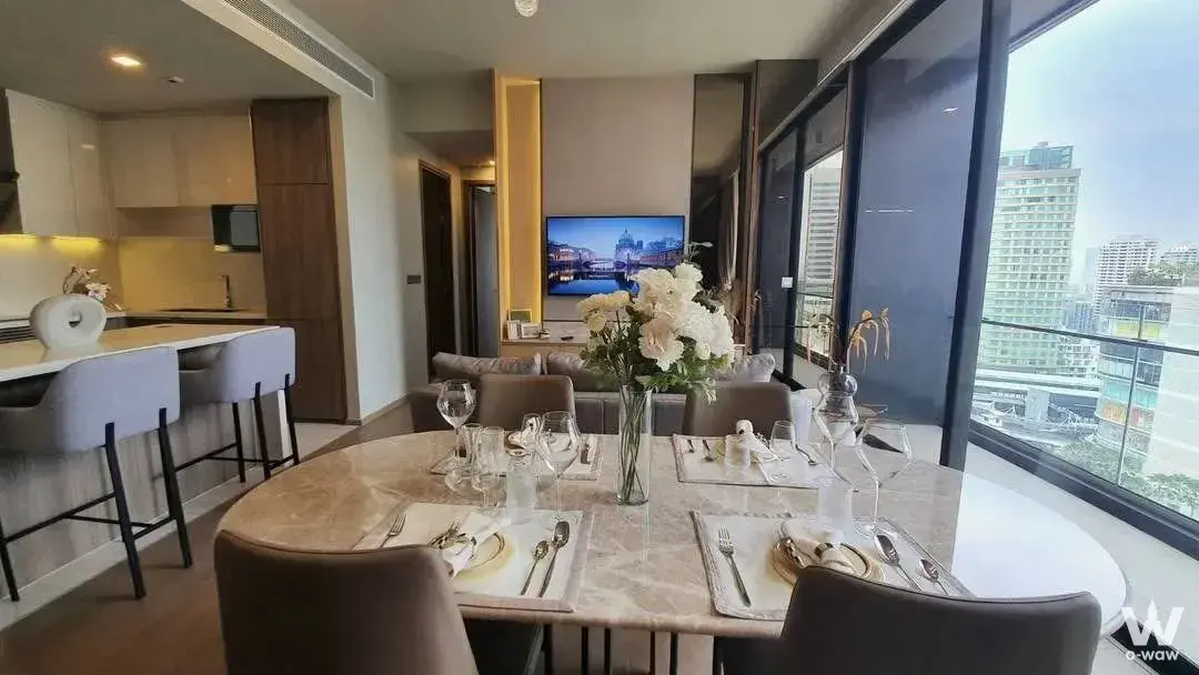 Open-plan dining area in a Celes Asoke condo featuring a marble table, quartz bar, and floor-to-ceiling city views
