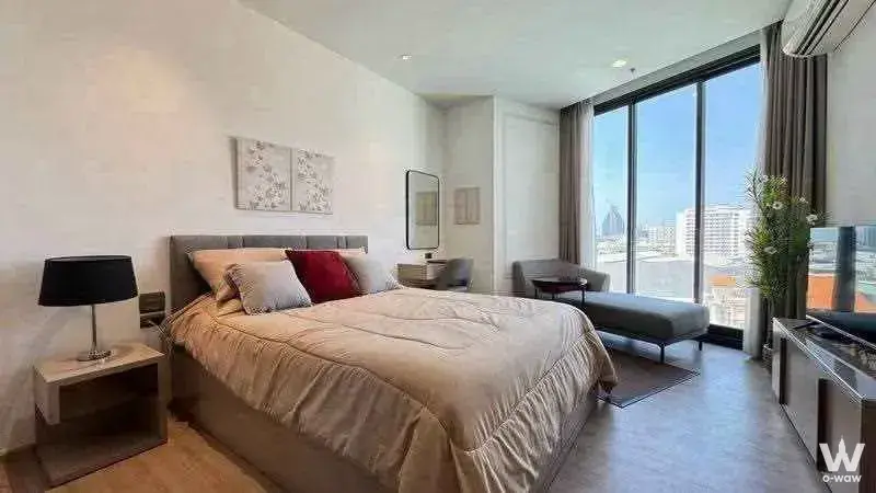 Edge Central Pattaya 1-bed for sale bedroom with king bed, city skyline view through floor-to-ceiling glass doors