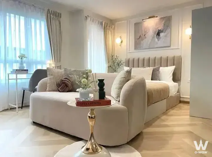 1-bed condo for sale in PG2 Condominium showcasing a luxury bedroom with beige velvet sofa, tufted headboard, and gold