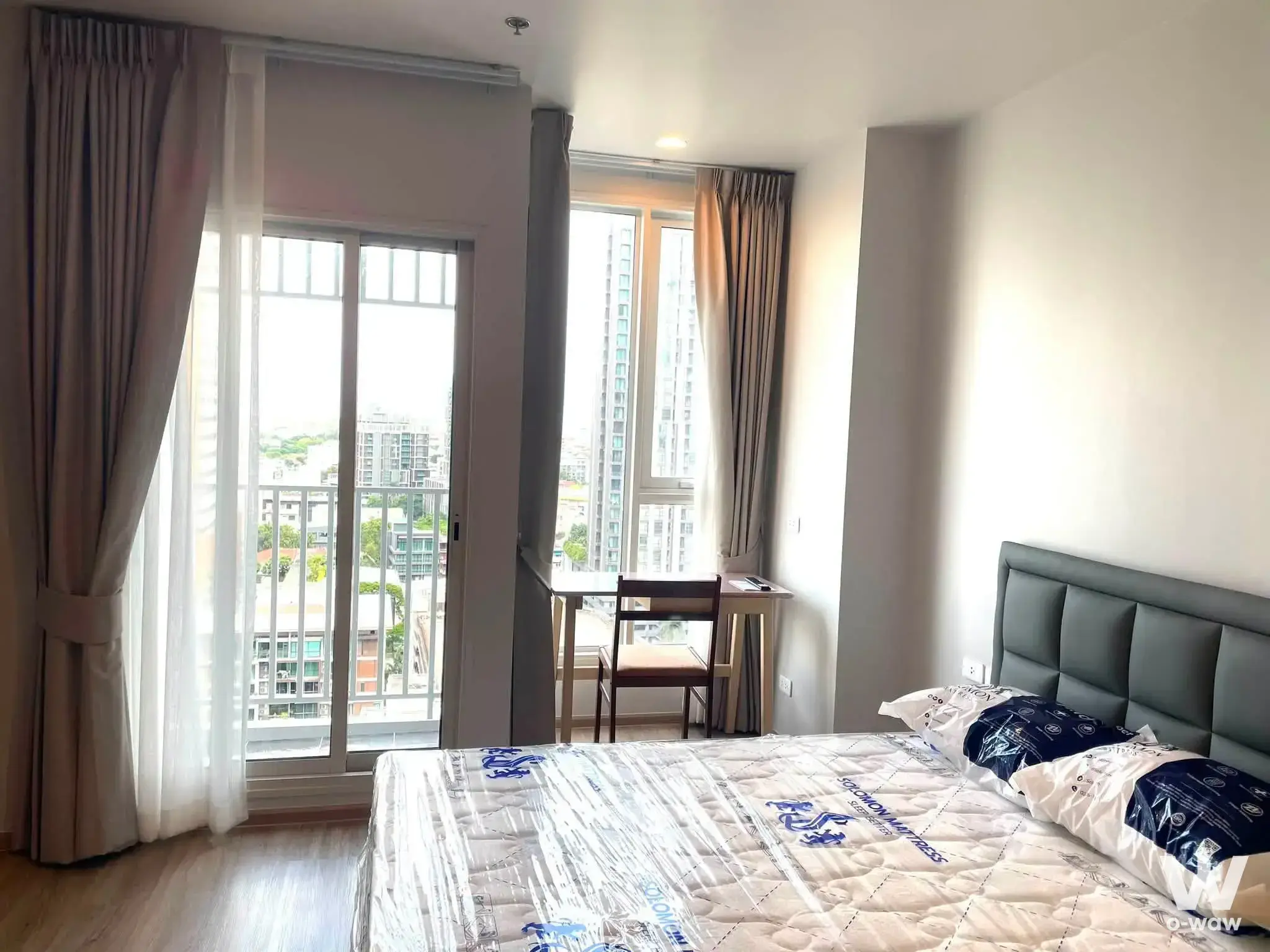 Culture Thonglor bedroom with a queen bed, sliding glass door, and city view from the balcony