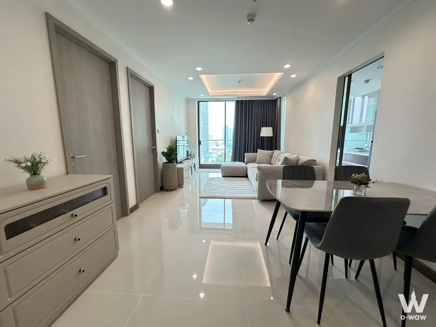 Living room in Supalai Oriental Sukhumvit 39 condo featuring L-shaped sofa and city skyline view