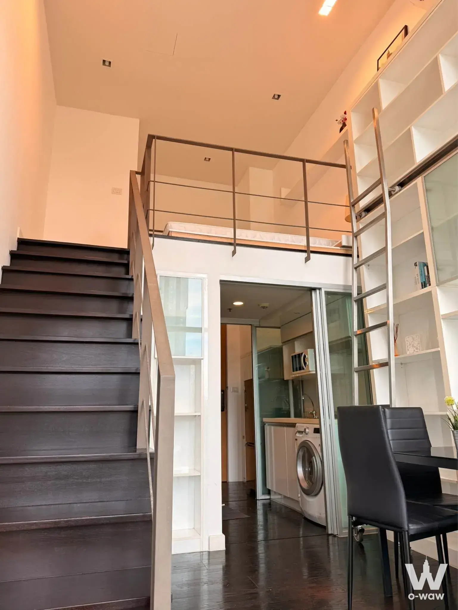 Ideo Morph 38 loft studio featuring a mezzanine bedroom, rolling ladder, and minimalist decor