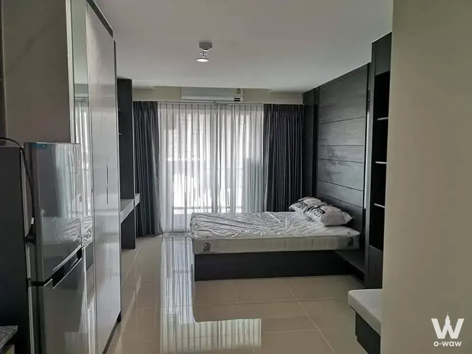 Minimalist studio bedroom for sale in ASAKAN Place Srinagarindra with dark wood headboard wall