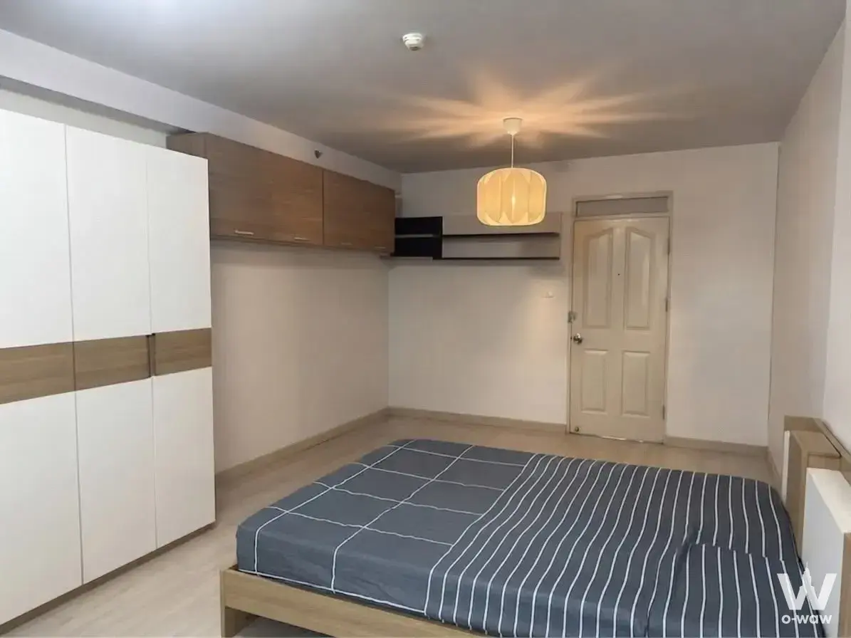 Cityhome รัชดา-ปิ่นเกล้า bedroom with white glossy wardrobe, blue striped bedding, and pendant lighting