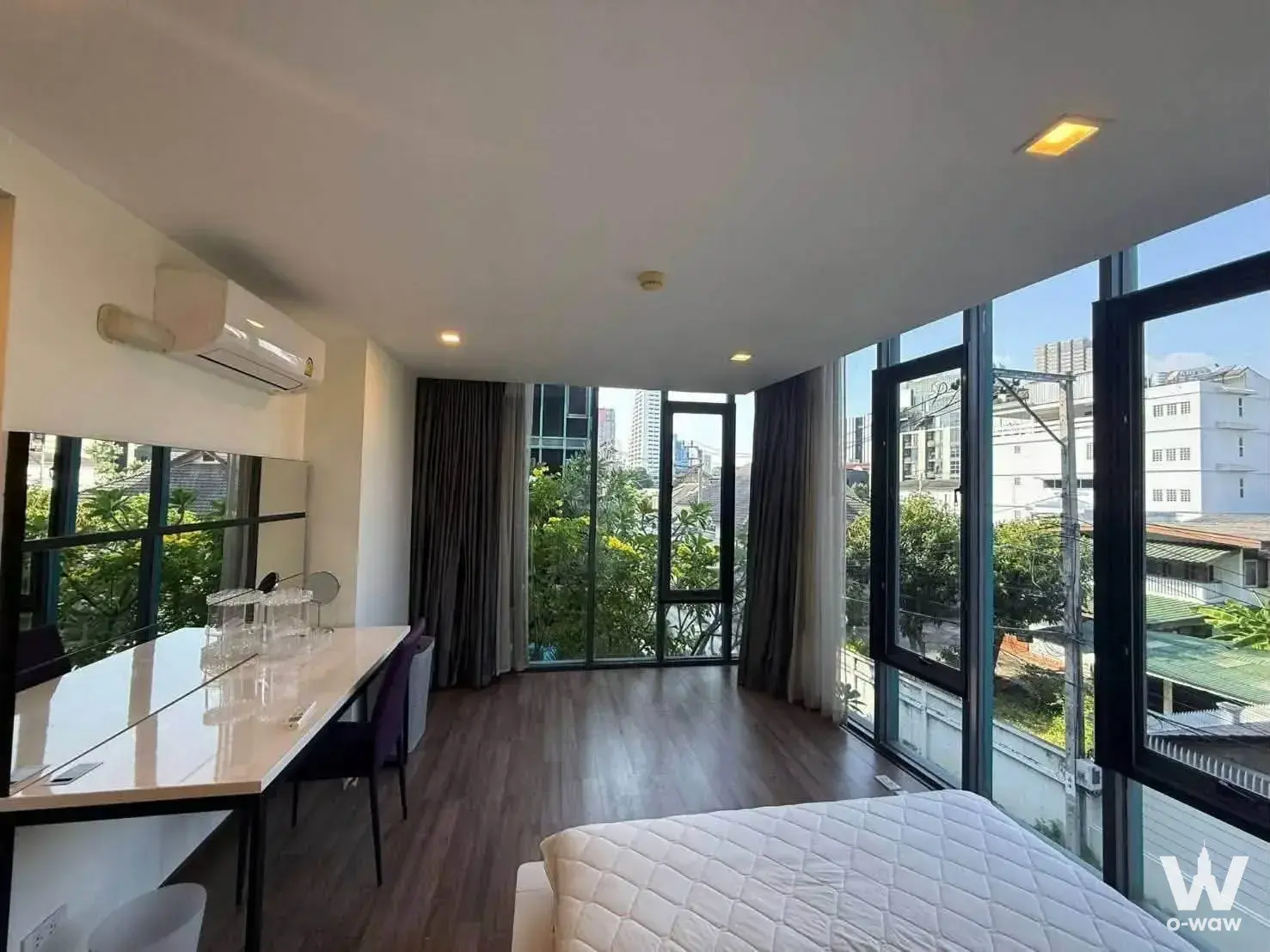Bedroom with city view, white desk, and purple chair in Prom Phaholyothin2 2-bed condo